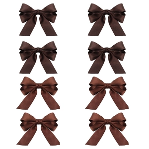 Detailed view of eight deep brown grosgrain bow hair clips in a symmetric pattern