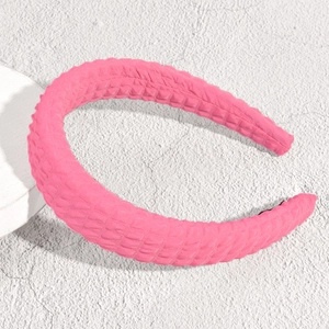Dettaglio del cerchietto rosa acceso con trama a bolle e finitura in tessuto morbido