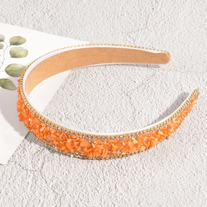 Detailed shot of orange crystal baroque headband with double-row white rhinestones
