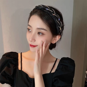 Détail d'un serre-tête tissé noir avec strass et texture élégante entrelacée