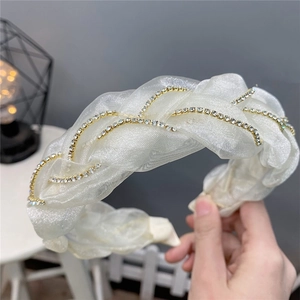Détail du serre-tête en organza avec chaîne en strass et texture tissée élégante