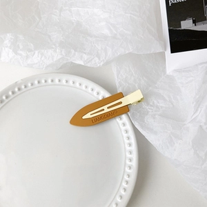 Detailed close-up of a minimalist metal duckbill hair clip with LIANGDIAN engraving
