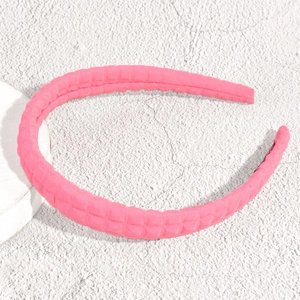 Dettaglio della fascia per capelli in tessuto a quadri rosa con trama trapuntata