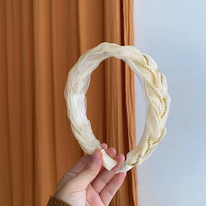 Détail du serre-tête en organza crème avec chaîne en strass dorée et dents antidérapantes