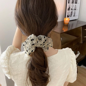 Elegant off-white mesh scrunchie with black polka dots and pearls on a ponytail