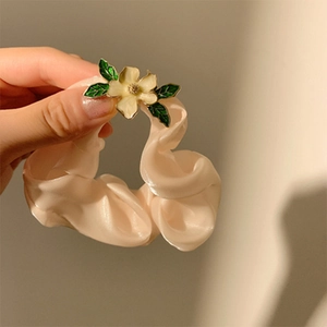 Eleganter aprikosenfarbener Satin-Haargummi mit Emaille-Blume für stilvolle Pferdeschwänze