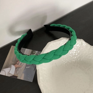 Close-up of green braided headband featuring a soft fabric texture and non-slip inner lining
