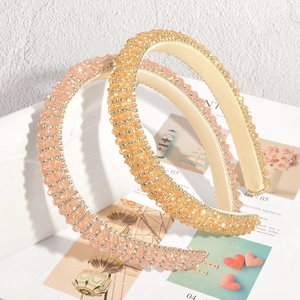 Detail von zwei breiten Kristall-Haarreifen mit Strassbesatz in Gold und Pfirsichfarben