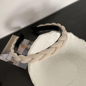 Detail of beige braided headband featuring anti-slip inner teeth and soft texture