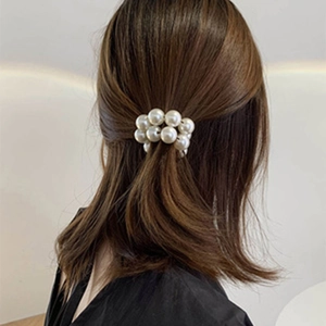 Eleganter weißer Perlen-Haargummi-Haarschmuck getragen an dunklem Frauenhaar