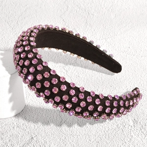 Close-up of pink crystal rhinestones on a padded black velvet headband