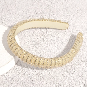 Detail eines champagnergoldenen breiten Haarreifs mit Kristallperlen und Glitzersteinen