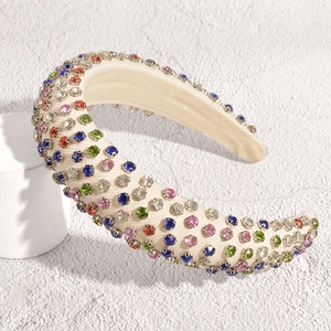 Macro detail of French style padded headband featuring colorful rhinestones on beige fabric