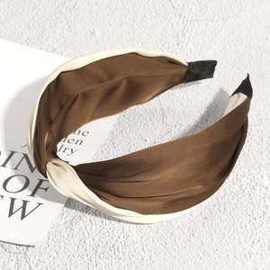 Detail view of bicolor cross knot headband with glossy brown and beige satin texture