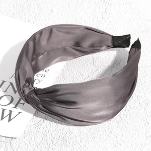 Detail view of a gray satin knotted wide headband with subtle silk luster and soft fabric