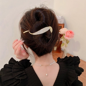 Detail of vintage gold alloy willow leaf hair clip with rhinestones worn by a model