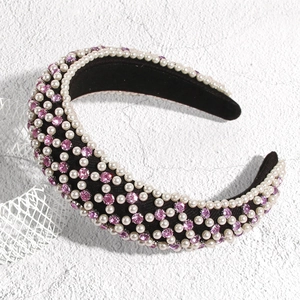 Détail d'un serre-tête en velours noir orné de perles blanches et strass violets