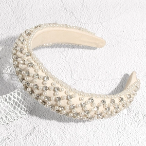 Détail du serre-tête rembourré avec perles blanches et strass brillants sur soie beige