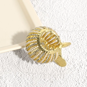 Macro detail of bird nest hair claw clip with rhinestones and white pearls