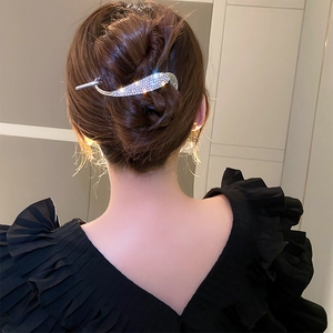 Elegant silver leaf hair pin with sparkling rhinestones worn on a stylish bun