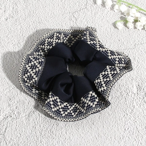 Detail of navy blue and checkered scrunchie fabric texture with lily decor