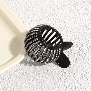 Close-up of black bird nest hair claw with sparkling rhinestones for ponytail styling