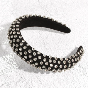 Détail d'un serre-tête en velours noir orné de strass brillants et design rembourré