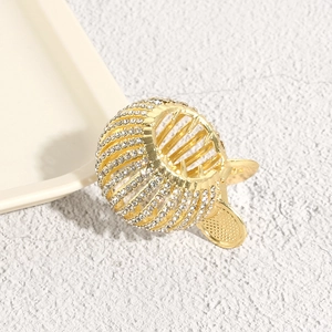Macro shot of bird nest hair claw with gold finish and sparkling rhinestones