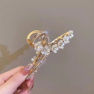 Elegante pinza per capelli dorata con fiori di camelia bianchi e strass scintillanti