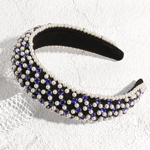 Détail du serre-tête en éponge noire orné de perles blanches et de cristaux bleus brillants
