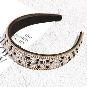 Detailed close-up of Baroque headband featuring black and white pearls with gold accents