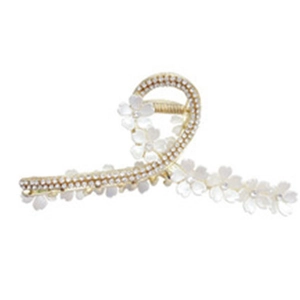 Elegante pinza per capelli a camelia dorata con strass e perle su sfondo bianco