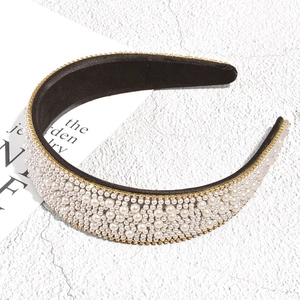 Close-up of luxury Baroque headband with white pearls and gold crystal chain edge