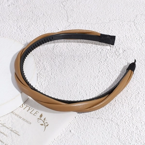 Détail du serre-tête en cuir marron torsadé avec dents antidérapantes et finition élégante