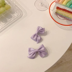 Gros plan de deux nœuds en satin lavande sur une table avec décor de dessert sucré