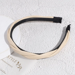 Détail d'un serre-tête en cuir tressé beige avec dents antidérapantes et style rétro