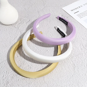 Three padded satin headbands in lavender, beige, and yellow with handmade labels