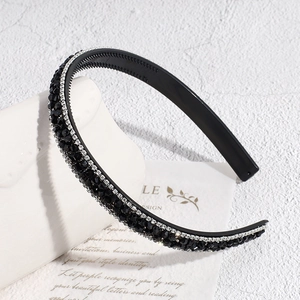 Détail d'un serre-tête noir perlé de cristaux avec dents antidérapantes et strass