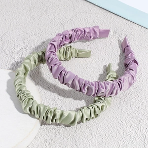 Pleated satin headbands in pastel purple and sage green with soft silk texture