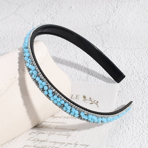 Détail d'un serre-tête baroque avec perles bleues, strass et petites dents antidérapantes