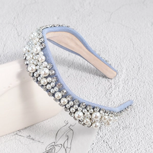 Détail d'un serre-tête en denim bleu clair avec perles blanches et strass brillants