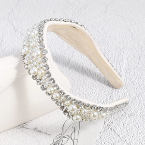 Vue détaillée du serre-tête en perles et strass sur des accessoires de décor blancs
