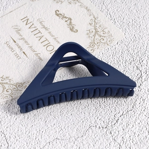 Detail view of large matte dark blue triangle hair claw clip with strong metal spring