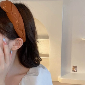 Detail of French style braided headband in caramel faux leather for high top volume