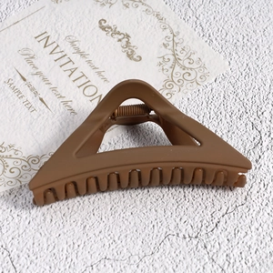 Detailed macro view of large matte dark brown triangular shark clip for women