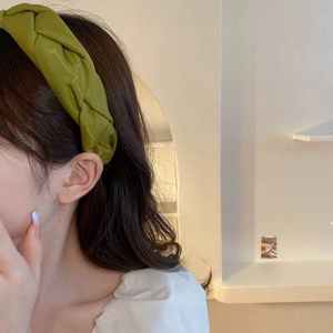 Elegant grass green braided headband with pleated fabric texture for a vintage chic look
