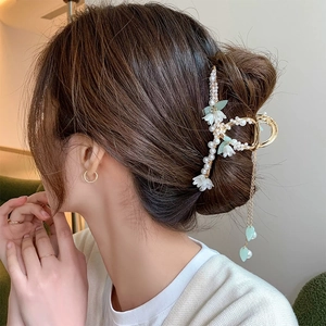 Elegant lily of the valley hair claw with pearls and long tassels on woman hairstyle