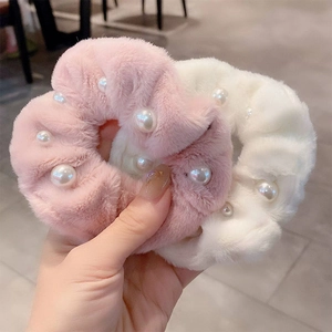 Gros plan de chouchous en peluche rose et blanc avec perles et fausse fourrure douce