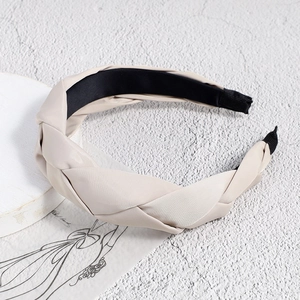 Close-up of beige braided headband with satin texture and black anti-slip lining
