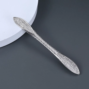 Gros plan d'une épingle à cheveux sertie de strass avec un design tissé sophistiqué